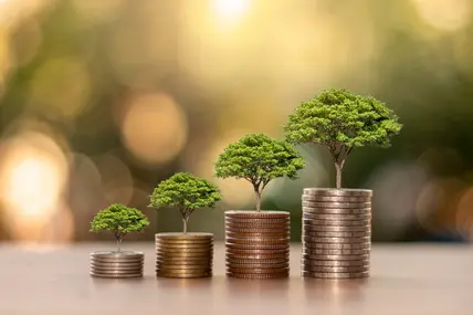 Wachstum durch Nachhaltigkeit; Bäume wachsen auf Geldmünzen 